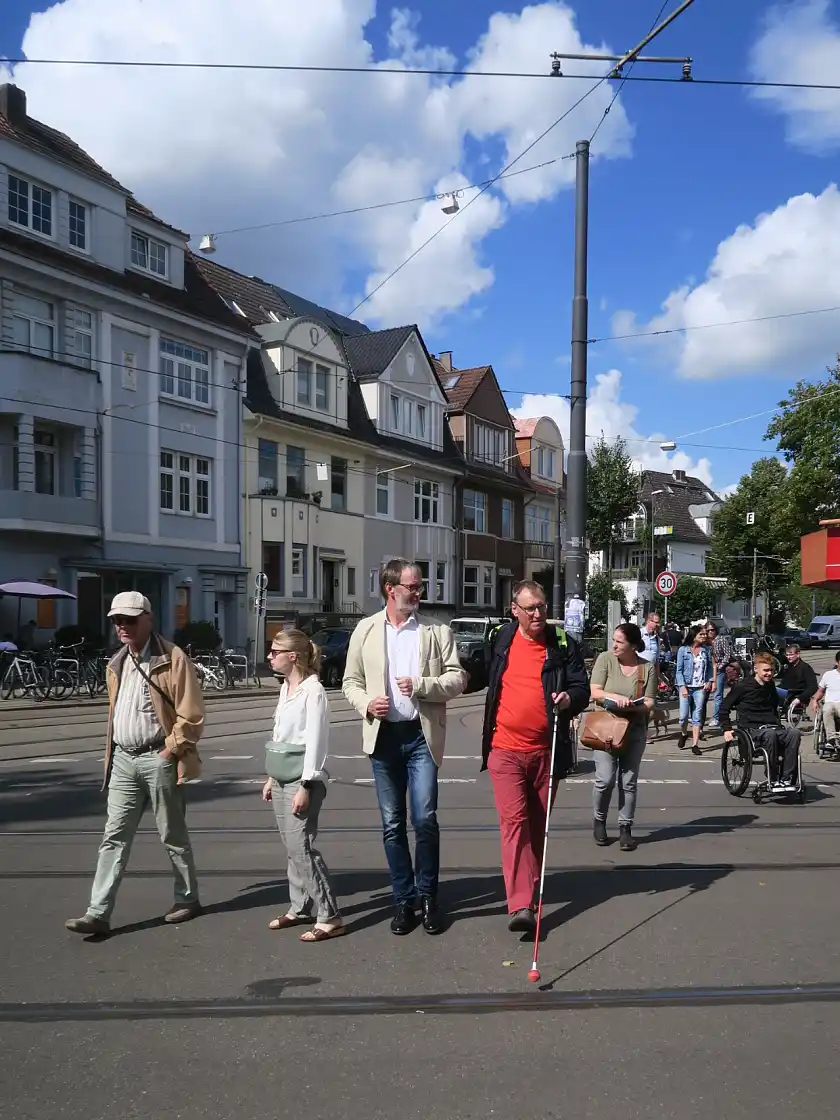 Ralf M&ouml;ller und Frank Mohrmann mit Blindenstock beim &Uuml;berqueren der Wachmannstra&szlig;e